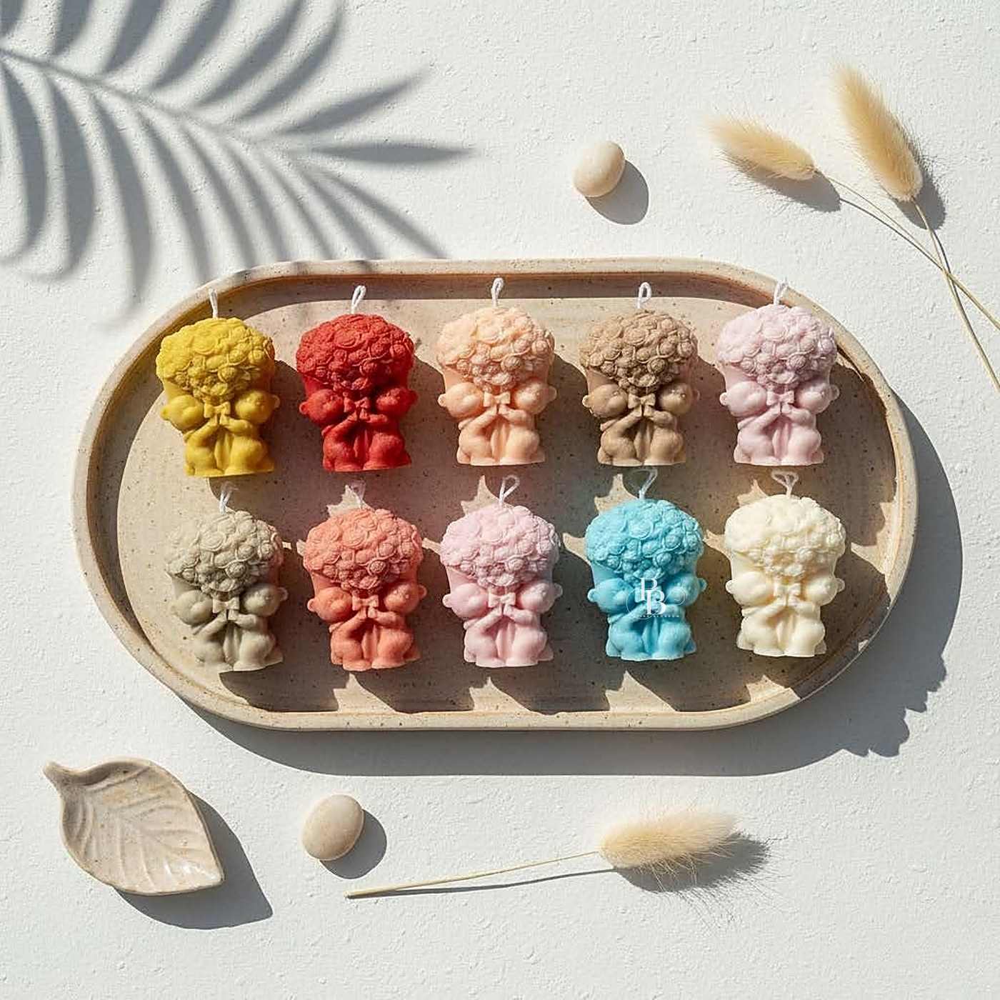 Curly-haired praying cherub candles arranged in rows on a tray, handmade soy wax, Pink Blossom bulk order